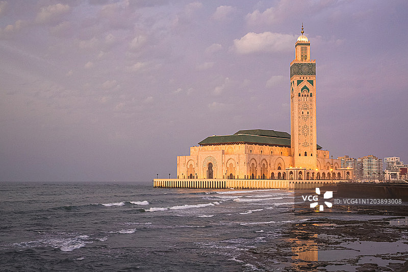 著名的哈桑二世清真寺沿着大西洋海岸的黄昏海浪，非洲摩洛哥卡萨布兰卡的地标图片素材