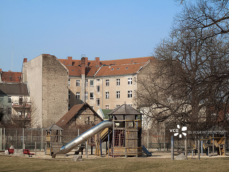 德国东柏林老住宅楼附近空荡荡的儿童游乐场图片素材