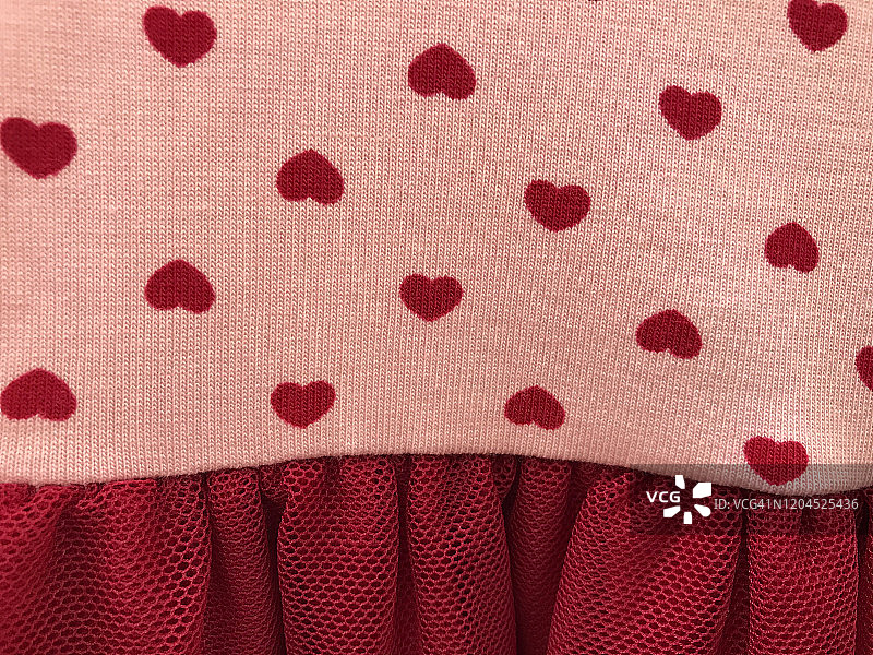 粉红色棉质针织物上的多个红色心形图案图片素材