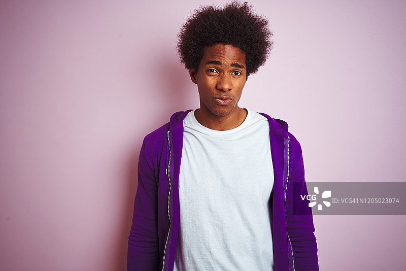 年轻的非洲裔美国人穿着紫色的运动衫站在孤立的粉红色背景沮丧和担心的痛苦，哭泣愤怒和害怕。悲伤的表情。图片素材