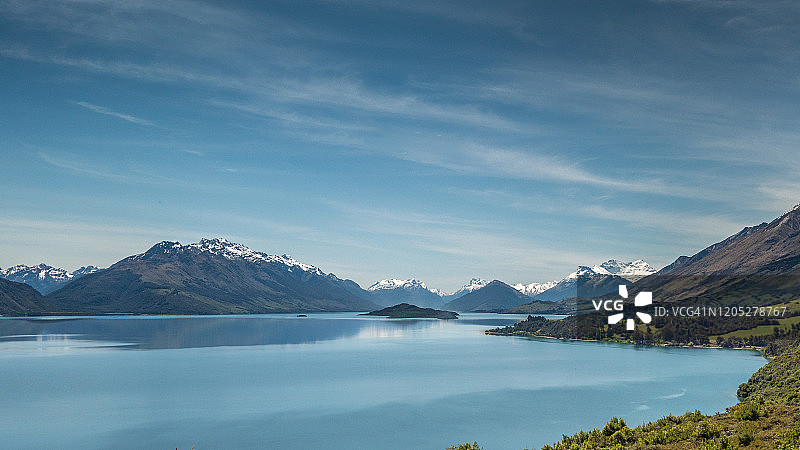 背景是新西兰南岛皇后镇附近美丽的蓝色瓦卡蒂普湖和南阿尔卑斯山图片素材