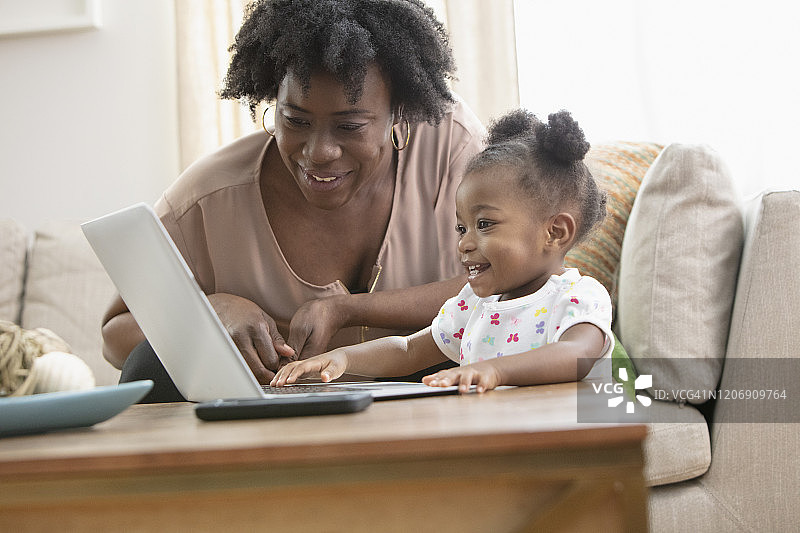 非裔美国母亲和她的小女孩在用电脑图片素材
