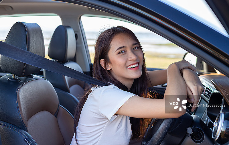 美丽微笑的年轻亚洲女人开车旅行图片素材