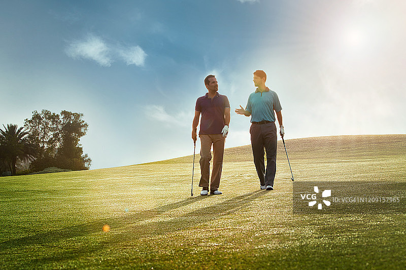两个人在高尔夫球场上散步，正面。图片素材