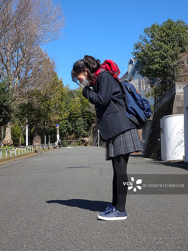 日本女学生穿着校服打喷嚏带着口罩图片素材