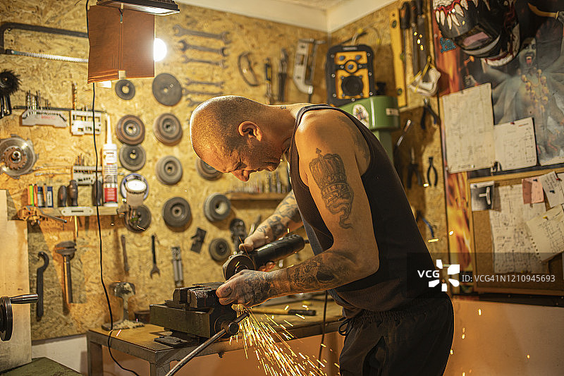 纹身艺术家用圆盘磨床切割钢材图片素材