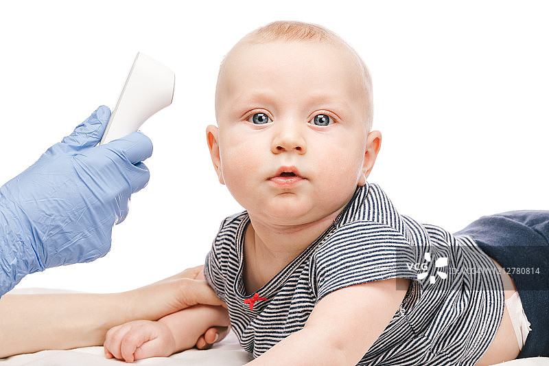 儿科医生用红外体温计检测男婴的体温图片素材