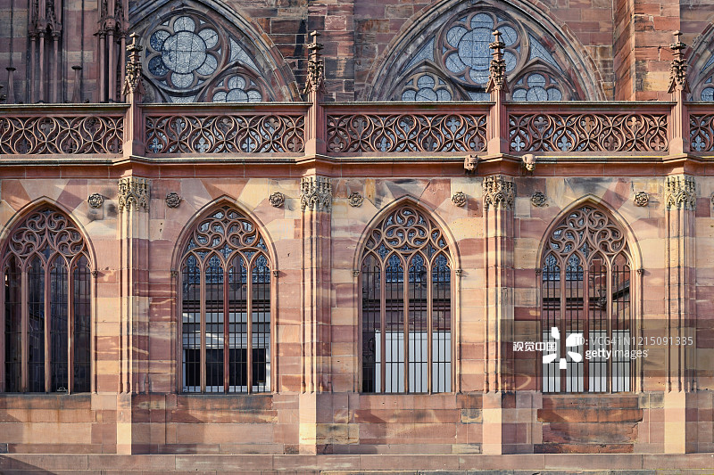 在法国著名的斯特拉斯堡大教堂一侧，有着罗马式和哥特式建筑风格的拱形窗户图片素材