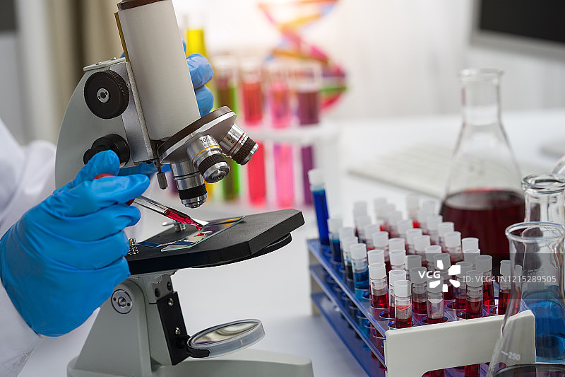 科学家利用显微镜在实验室对血液样本进行遗传学研究。图片素材