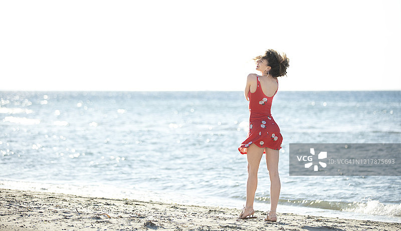 一个年轻女子独自走在海滩上图片素材