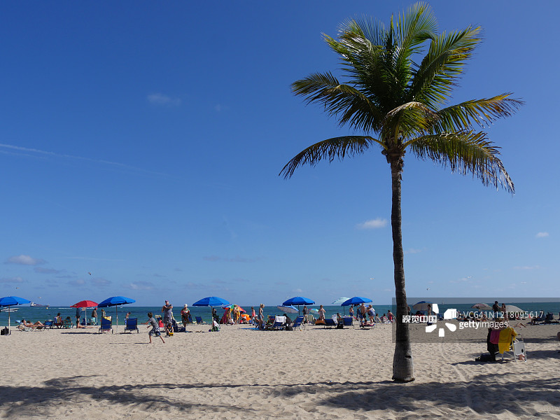 白色沙滩的迈阿密海滩，海滩游客分散在岸边。图片素材