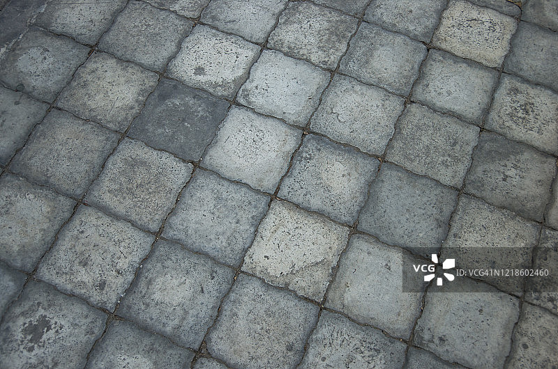 人行道上互锁的灰色方形水泥铺砖图片素材