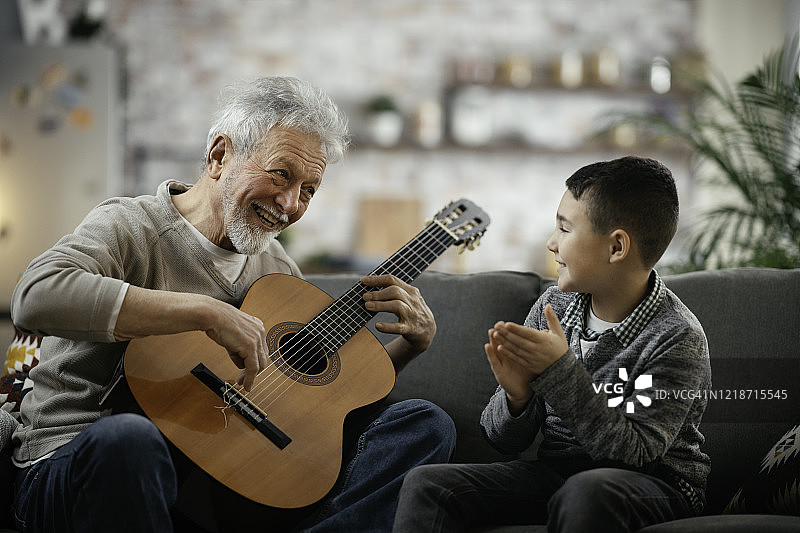 爷爷和孙子在弹吉他。图片素材
