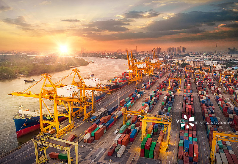 货轮鸟瞰图，泰国仓库港口的货物集装箱，进出口集装箱船，夕阳下的商业物流图片素材