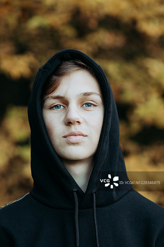 一个十几岁的男孩站在户外的秋天，荷兰图片素材