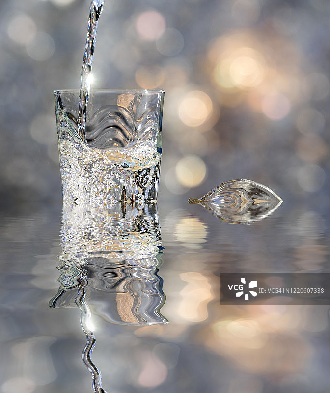 一杯水晶与水的冲击，落在水中反射。图片素材