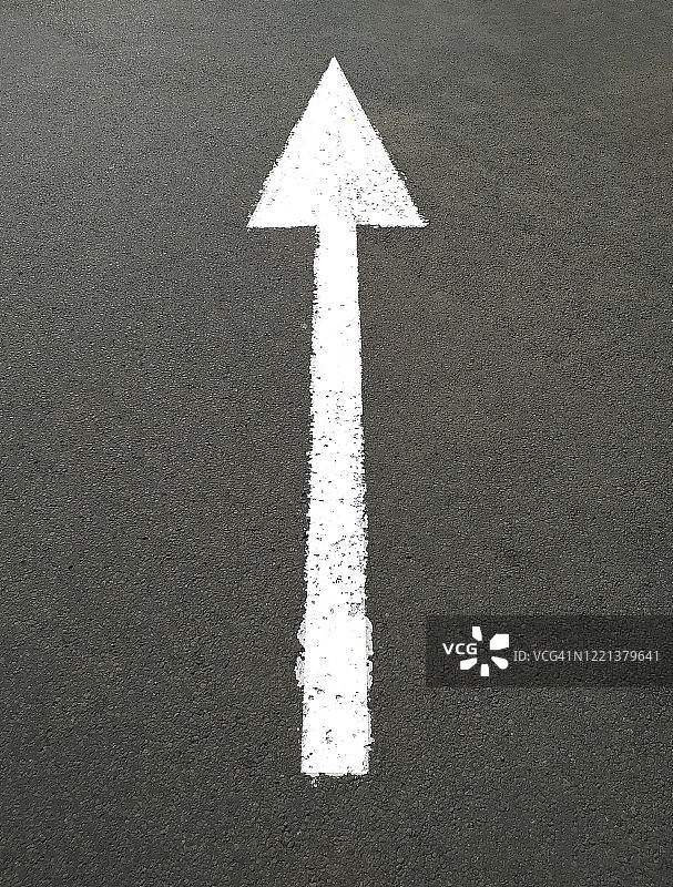 白色的向前交通箭头画在沥青上。交通标志直走。人行道上的道路标记。图片素材