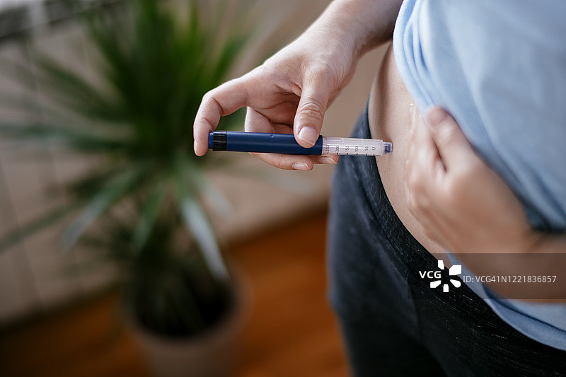 一个女人在胃里注射胰岛素。库存图片图片素材