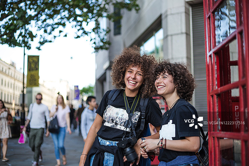 憨厚的微笑卷曲的头发的兄弟姐妹享受在城市的一天图片素材