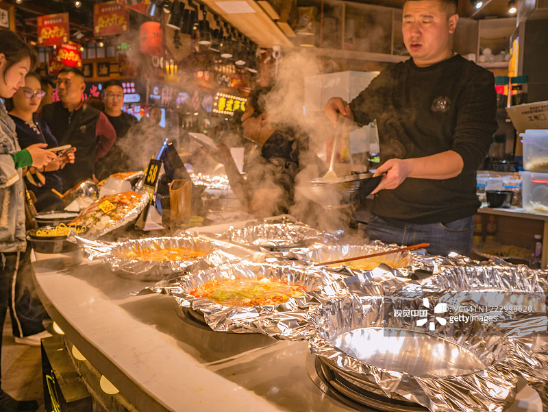 中国长沙市街头小吃巷子里的陌生人和厨师。长沙是中国湖南省的省会和人口最多的城市图片素材