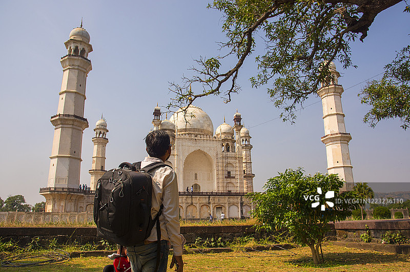 印度马哈拉施特拉邦奥兰加巴德Bibi ka Maqbara前，一名背着背包的游客图片素材