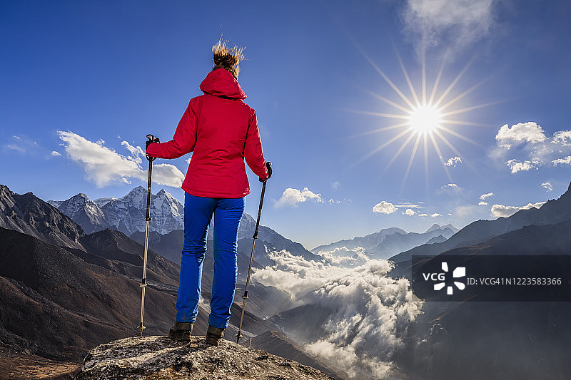 在喜马拉雅山的埃佛勒斯峰国家公园，一名女子在山顶欣赏风景，图片素材