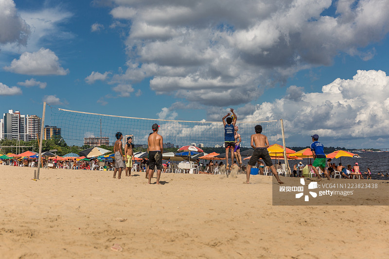 当地巴西人在马瑙斯的蓬塔尼格拉海滩上玩沙滩排球，巴西，南美洲亚马逊河图片素材