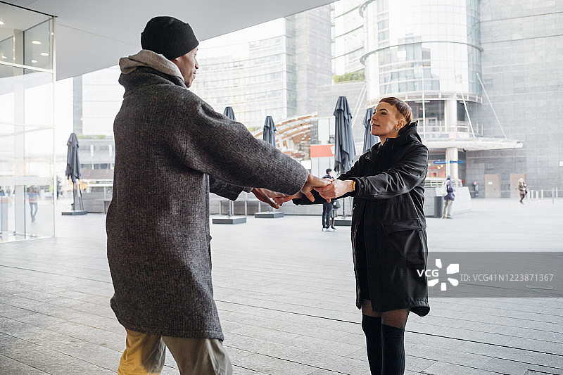 一对年轻夫妇在城市里牵着手图片素材
