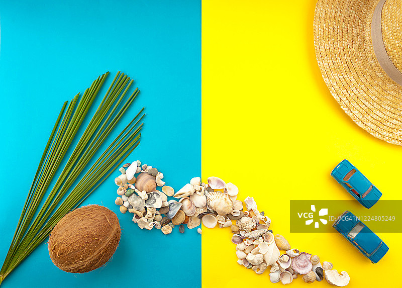 夏天旅游的概念。棕榈树叶子，草帽，椰子，贝壳，黄色背景上的蓝色汽车图片素材