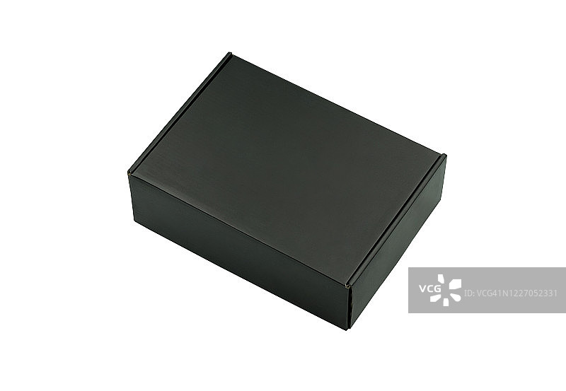 封闭的哑光黑色纸箱的特写在白色背景与剪切路径。模型设计，纸箱产品的包装运输和仓库储存。瓦楞纸可以回收利用。图片素材