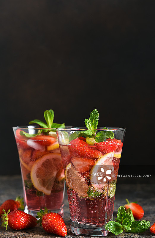 柠檬水，草莓和薄荷在深色混凝土背景。夏天冷饮。图片素材