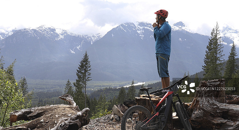 山地自行车站在树桩之上的山谷，山脉和森林图片素材