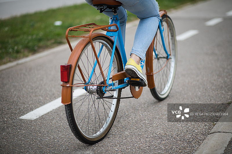 女人骑着蓝色复古城市自行车的特写图片素材