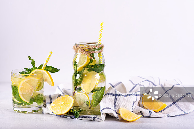 柠檬水加冰的花式玻璃杯和吸管，有柠檬和半杯。图片素材