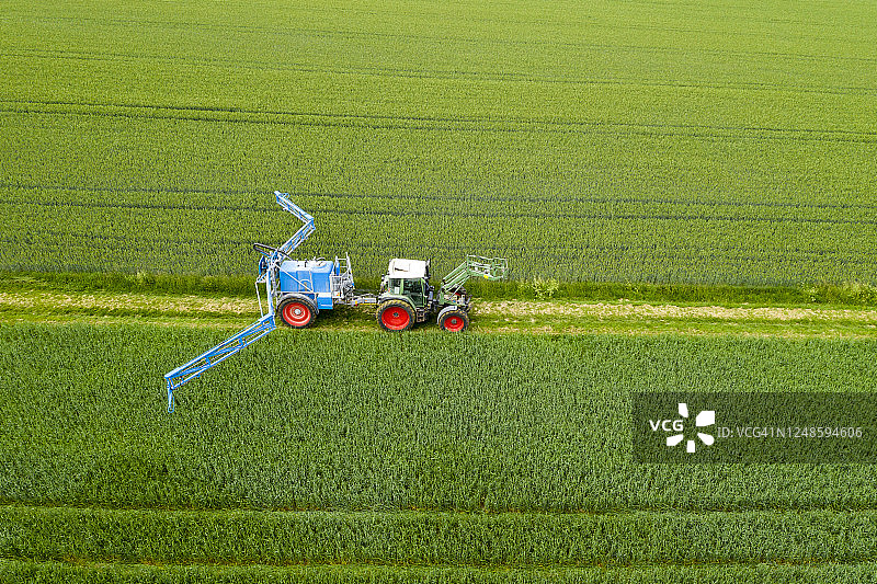 拖拉机向麦田喷洒农药，鸟瞰图图片素材