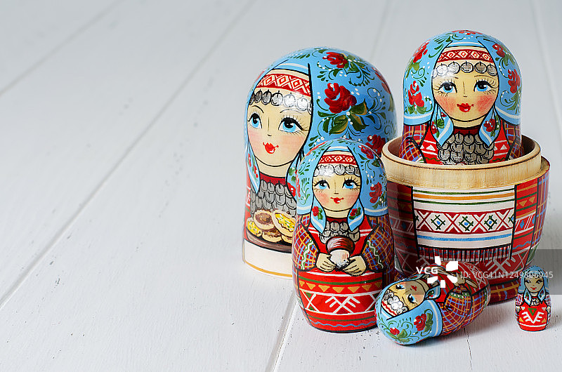 五个红色的套娃。传统的俄罗斯玩具。副本的空间。白色木制背景图片素材
