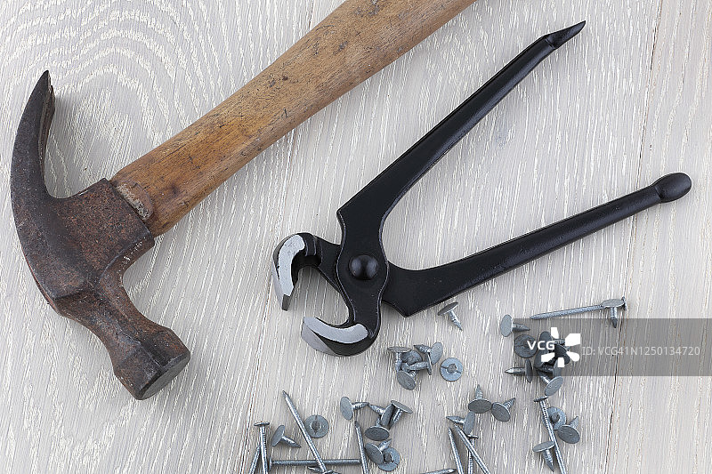 工具:木匠，钳子，钳子，羊角锤，钉子和木头上的大头钉图片素材