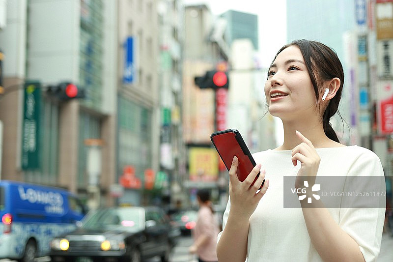 一个亚洲女人在用智能手机图片素材