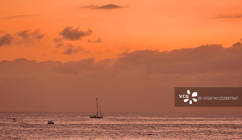 日落时分，印度洋上的帆船在留尼旺海岸图片素材