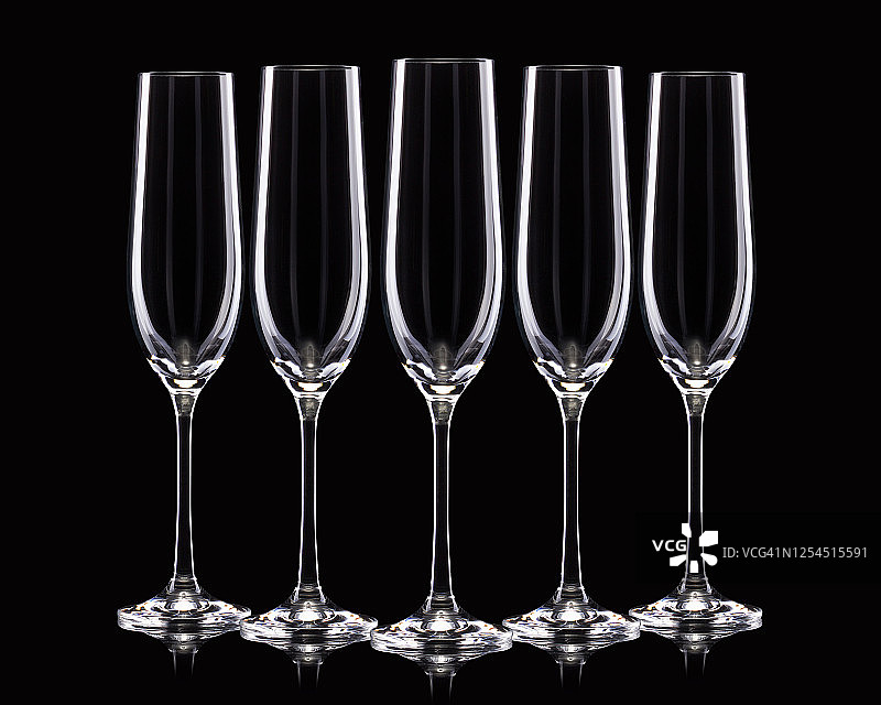 一组空的豪华香槟酒杯在一排孤立的黑色背景图片素材