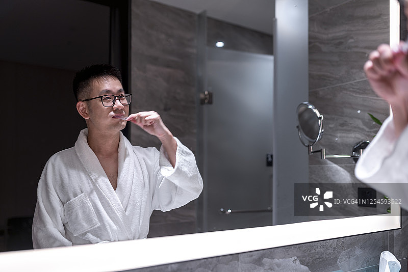 在浴室刷牙的亚洲男人图片素材
