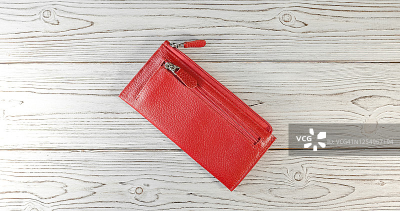 木板背景上的红色钱包。前视图。Flatlay图片素材