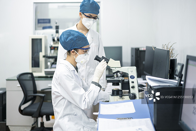两个亚洲女性医生在实验室看显微镜图片素材