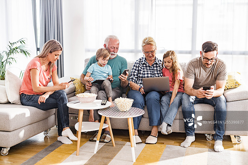 多代家庭在家中使用无线技术。图片素材