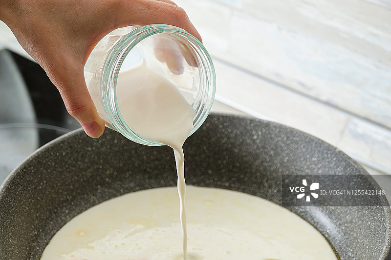 在家用奶油酱和罗勒烹饪意大利面。将奶油倒入油炸的大蒜和香料中。素食。一步一步的指导，自己做。步骤7。图片素材