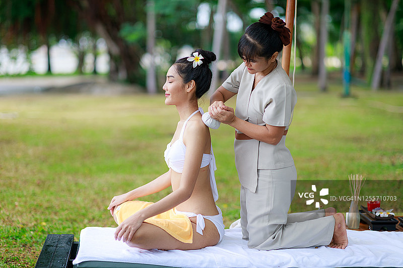 亚洲女性游客享受泰国温泉按摩与草药在花园里图片素材