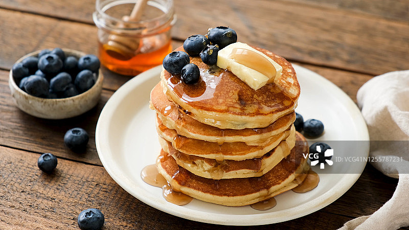 早餐煎饼配蓝莓，黄油和蜂蜜图片素材