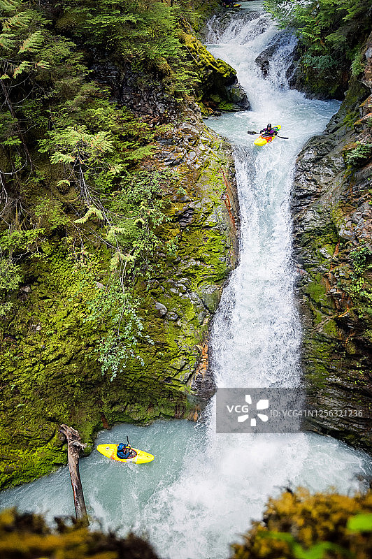 划桨者乘坐皮艇从垂直的瀑布中下降图片素材