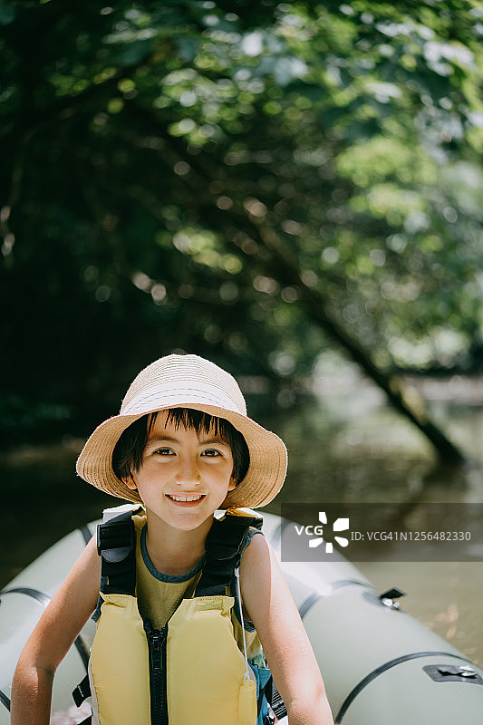 可爱的小女孩在筏子上对着相机微笑图片素材