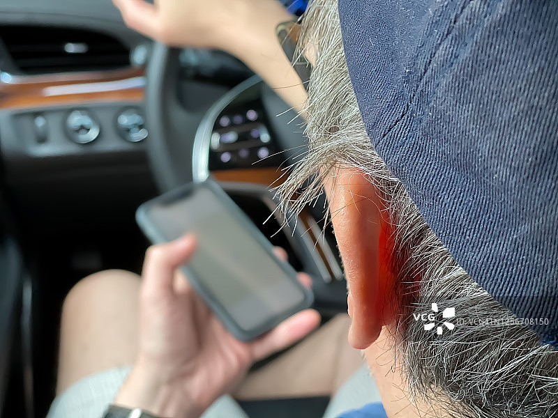 爸爸在家里的车里等红灯的时候用手机来导航图片素材
